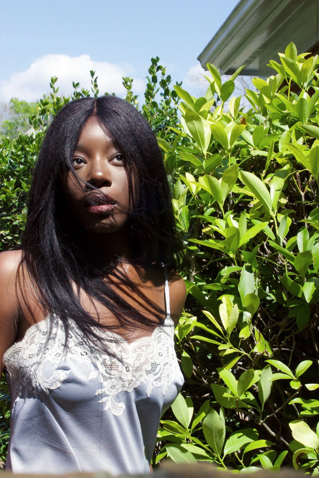Noa Omane outdoors in satin slip dress